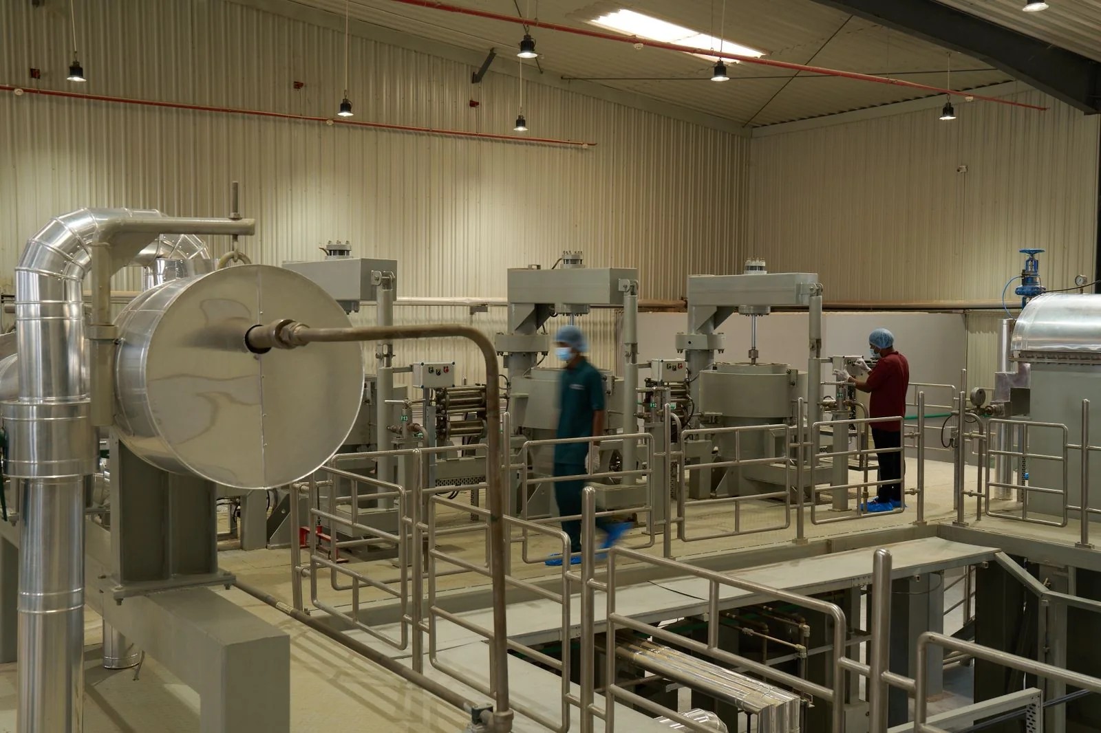 Technicians working across a commercial food processing hall during a production run
